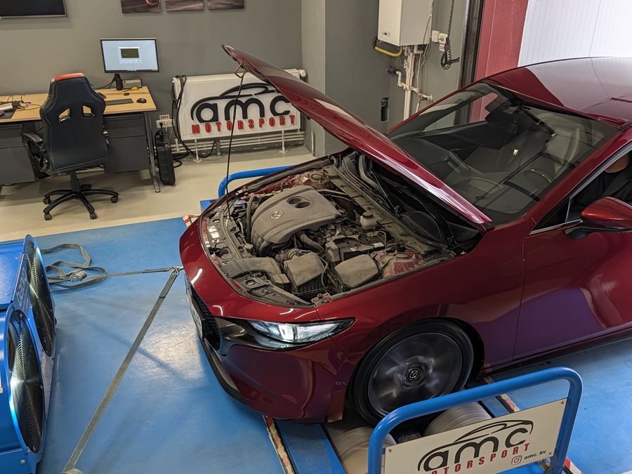 Mazda 3 rosie cu capota motorului ridicata, pe stand