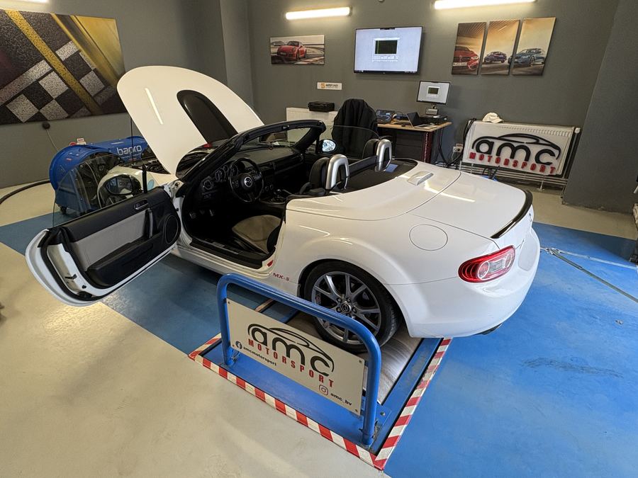 Mazda MX-5 alb decapotabil pe stand, cu usa deschisa